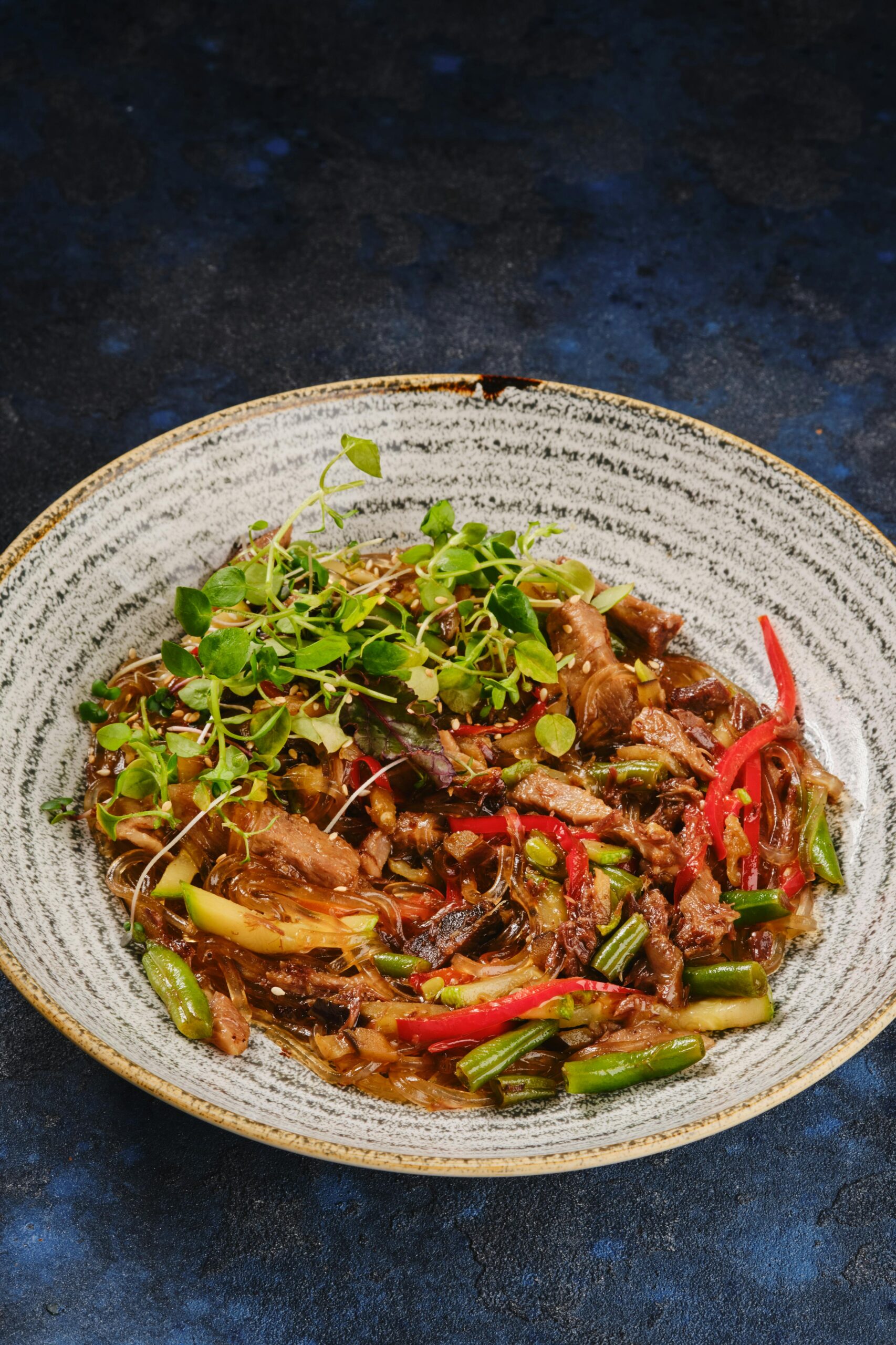 Delicious stir-fried noodles with beef, peppers, and greens in a traditional Chinese style.