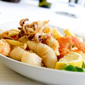 Delicious Italian Fritto Misto featuring shrimp, squid, and lemon slices. Perfect for seafood lovers.