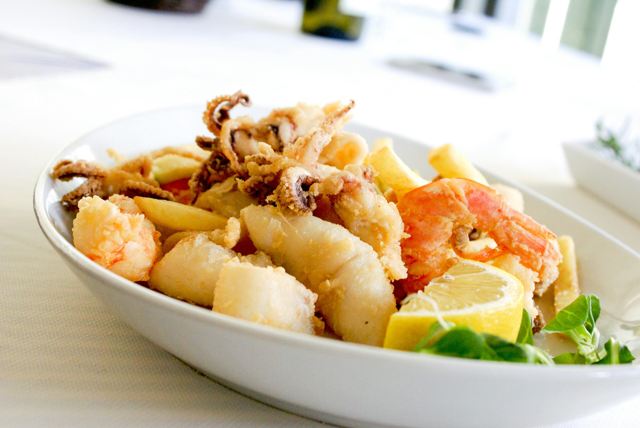 Delicious Italian Fritto Misto featuring shrimp, squid, and lemon slices. Perfect for seafood lovers.